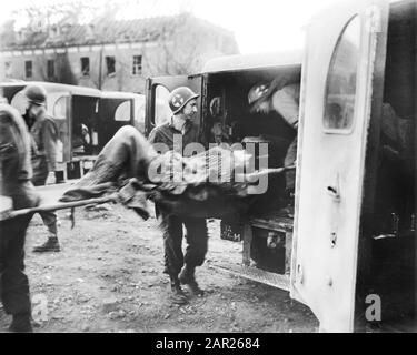 American Medics platziert einen Verletzten deutschen Sklaven in Ambulanz im German Slave Labor Camp zur Zeit der Befreiung durch die US-Armee, Nordhausen, Deutschland, Foto von Roberts für das US Army Signal Corps, April 1945 Stockfoto