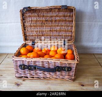 Hamper-Korb Voller Frischer Orangen auf Holztisch Stockfoto