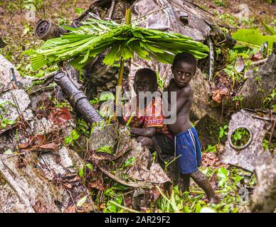 Zwei Jungen mit selbstgemachten Regenschirmen im Dschungel von Bougainville, Papua-Neuguinea Stockfoto