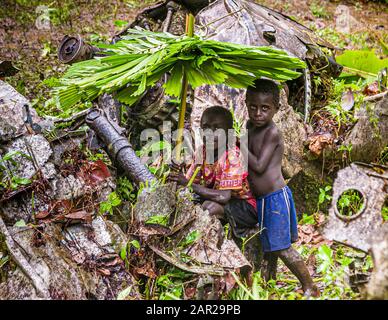 Zwei Jungen mit selbstgemachten Regenschirmen im Dschungel von Bougainville, Papua-Neuguinea Stockfoto