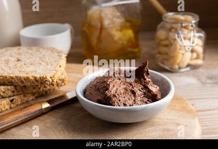 Hausgemachte vegane Schokolade in einer kleinen Schüssel aus Mandelbutter, Kakao und Honig. Stockfoto