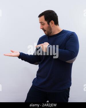 Junger gutaussehender Mann gegen weiße Wand Stockfoto