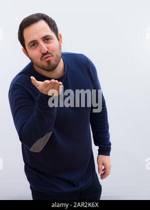 Junger Gutaussehender Mann, der einen Kuss an die Kamera schickt Stockfoto