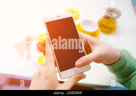 Nahaufnahme der Hände von Frauen, die das Handy mit einem leeren Bildschirm für den Kopierbereich halten. Selektiver Fokus, Nahaufnahme Stockfoto