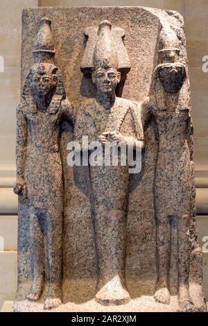 Dreifache Statue aus rotem Granit in der Galerie ägyptischer Antiquitäten im Sully Flügel des Louvre Museum (Musée du Louvre) in Paris, Frankreich Stockfoto