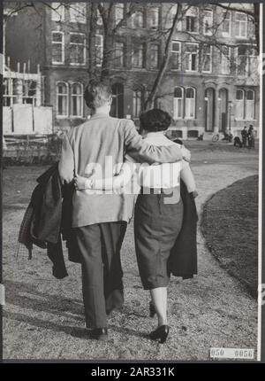 The mercury suddenly rises in the thermometer. This young couple took the winter coats over the arm during a walk through the park Date: March 5, 1954 Stockfoto
