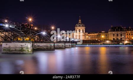 Paris pont des Arts führt zum Institut de France, mit einer nächtlichen Langzeitbelichtung Stockfoto