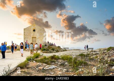 Touristen gehen auf dem Weg zur Römisch-katholischen Maria-Magdalena-Kapelle mit Blick auf die Dingli-Klippen auf der Malteserinsel Stockfoto