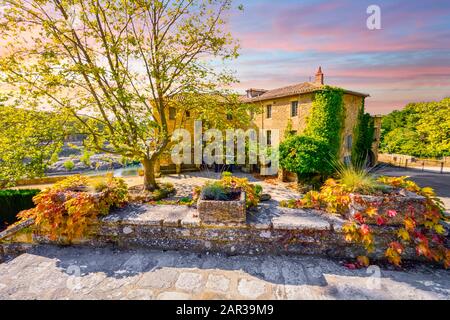 Ein farbenfroher Himmel und Sonnenuntergang über einem historischen Stuck- oder Landsitz entlang eines Flusses im südfranzösischen Gebiet der Provence im Herbst. Stockfoto