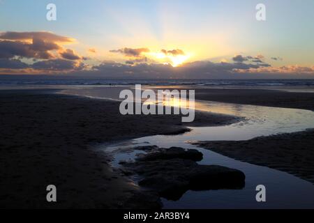 Der Bach fließt bei Sonnenuntergang über den Strand in der Dunraven Bay, in der Nähe von Southerndown, South Glamorgan, Wales, Großbritannien Stockfoto