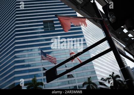 Blick auf das Gebäude des Miami Tower in der Innenstadt von Miami mit Fahnen und Metromover Gleisen im Rahmen Stockfoto
