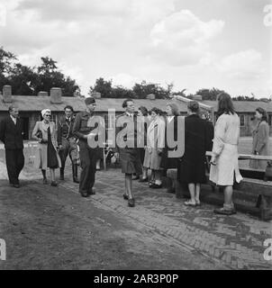 Reportage; Camp Amersfoort, Internierungslager für Kriegsverbrecher und Kollaborateure Anmerkung: Oder Frauenlager Vught? Eine Dame besucht das Lager, begleitet von einer Reihe von Männern. Vorne befindet sich eine Wache. Datum: 1945 Schlüsselwörter: Gefangene, Internierungslager, Frauen Stockfoto