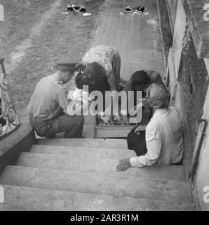 Landrätin in Frankreich Nimmt Unter der Aufsicht von 2 Männern Kleider aus einem Koffer. Eine andere Frau beobachtet Datum: August 1945 Ort: Frankreich Schlagwörter: Reinigung, Zusammenarbeit, zweiter Weltkrieg Stockfoto