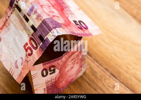 High-Angle-Aufnahme von einigen südafrikanischen Rand Rechnungen auf Eine hölzerne Oberfläche Stockfoto