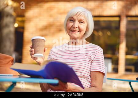 Hübsche Frau, die eine Tasse Kaffee trinken wird Stockfoto