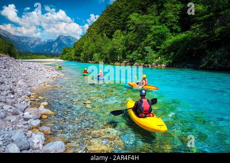 Berühmter Rafting- und Kajakplatz. Aktive Kajakfahrer in farbenfrohen Life-Jacket-Paddeln und Sport auf dem smaragdfarbenen Soca River, Bovec, Triglav Nat Stockfoto