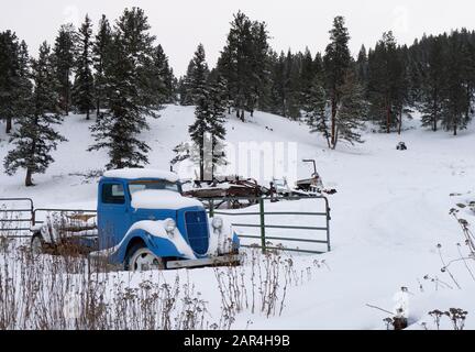 Ein Ford-LKW von 1935, der im Schnee bedeckt ist, auf einer Farm in Beavertail, Montana. Stockfoto