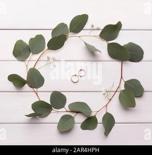 Hochzeit klingelt in einem Blumenkopfband auf einem Holztisch Stockfoto