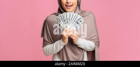 Dollar-Bargeld in Händen von nicht erkennbaren muslimen in Hijab Stockfoto