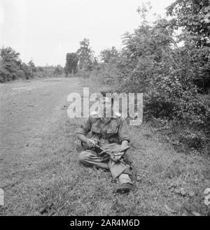 Reinigungsaktion Tangerang 4-11 RI und 4-9 RI EIN Sergeant sitzt mit einem Gewehre auf seinem Schoß und einer brennenden Zigarette im Straßenrand Datum: September 1947 Ort: Indonesien, Niederländische Ostinseln Stockfoto