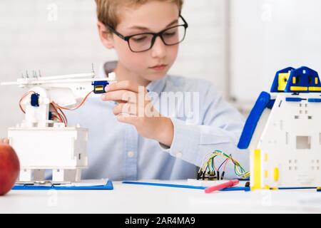 Kluger Schuljunge bei der Stammstunde beim Bau von Robotern Stockfoto