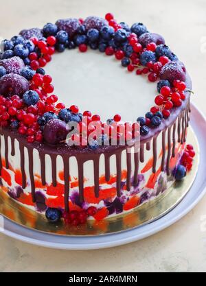 Heller festlicher Kuchen mit Beeren und Schokolade auf weißem Hintergrund Stockfoto