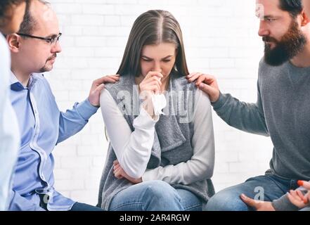 Gruppenmitglieder unterstützen aufgebrachten Frauen häusliche Gewalt Opfer auf der Therapiesitzung Stockfoto