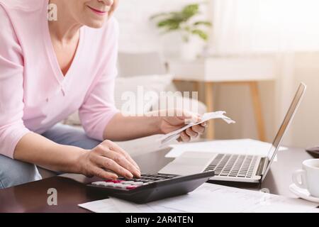 Seniorin rechnet Rechnungen mit Rechner zu Hause Stockfoto