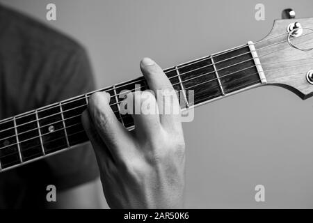 Männer fangen Akkorde lernen Gitarre zu spielen. Closeup-Musiker fangen Gitarrenakkorde. Männliche Musiker halten Akkorde und Strum Gitarre. Stockfoto