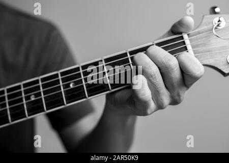 Männer fangen Akkorde lernen Gitarre zu spielen. Closeup-Musiker fangen Gitarrenakkorde. Männliche Musiker halten Akkorde und Strum Gitarre. Stockfoto