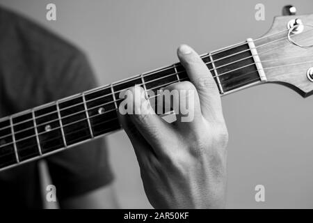 Männer fangen Akkorde lernen Gitarre zu spielen. Closeup-Musiker fangen Gitarrenakkorde. Männliche Musiker halten Akkorde und Strum Gitarre. Stockfoto