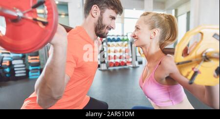 Ein Paar Frau und Mann in der Sporthalle mit Gewichten im Wettkampf Stockfoto