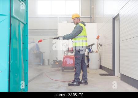 Arbeitnehmer Reinigung einen Mietwagen oder mobile Toilette Stockfoto