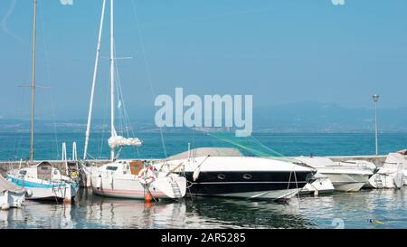 Ein kleiner Hafen mit vielen weißen Segelbooten und Sportyachten, die an einem sonnigen Tag geparkt sind Stockfoto