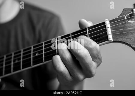 Männer fangen Akkorde lernen Gitarre zu spielen. Closeup-Musiker fangen Gitarrenakkorde. Männliche Musiker halten Akkorde und Strum Gitarre. Stockfoto