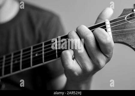 Männer fangen Akkorde lernen Gitarre zu spielen. Closeup-Musiker fangen Gitarrenakkorde. Männliche Musiker halten Akkorde und Strum Gitarre. Stockfoto