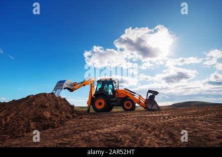 Radlader Bagger mit Feld Hintergrund während der erdarbeiten, Bau Gebäude Stockfoto