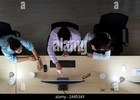 Bis spät in die Nacht Umwelt, Blick von Oben auf die jungen Erwachsenen freundlich operator Team mit Headsets über den Fall diskutieren in einem Call Center customer service Stockfoto