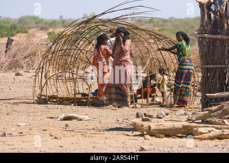 Junge Frauen Aus Der Ferne, die ein Nomadenzelt bauen, Afar-Region, Äthiopien. Die Vorfahren der Afar besiedelten einige Zeit befo Bauernland im äthiopischen Hochland Stockfoto