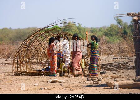 Junge Frauen Aus Der Ferne, die ein Nomadenzelt bauen, Afar-Region, Äthiopien. Die Vorfahren der Afar besiedelten einige Zeit befo Bauernland im äthiopischen Hochland Stockfoto