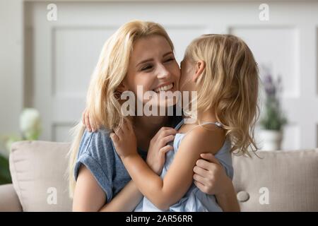 Freudige junge Mutter spielt mit kleiner Tochter. Stockfoto