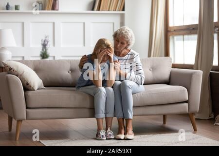 Empathische Mutter mittleren Alters, die Unterstützung für Erwachsene Tochter zeigt. Stockfoto