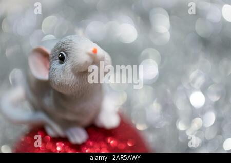 Spielzeugmaus auf einem Weihnachtsball Nahaufnahme auf einem Hintergrund mit Bokeh. Das Jahr der Ratte ist 2020 nach dem östlichen Kalender. Symbol des Jahres. Stockfoto