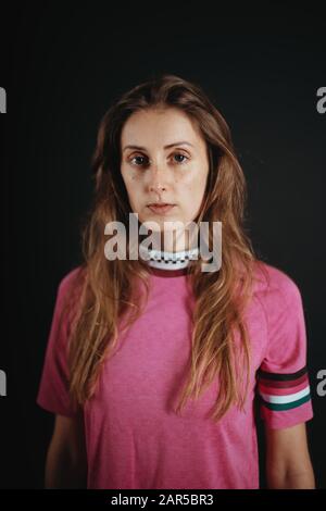 Porträt einer schönen jungen Frau, die ein rosafarbenes Hemd trägt Stockfoto