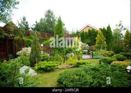 Privater Garten mit einer großen Vielfalt an Vegetation, der dicht beieinander gepflanzt wird Stockfoto