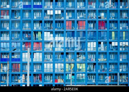 Mehrfaches Foto des mehrstöckigen Gebäudefragments, das den blauen Himmel reflektiert. Strukturelle Glaswand mit kurvenförmigen Formen. Moderne Architektur Stockfoto