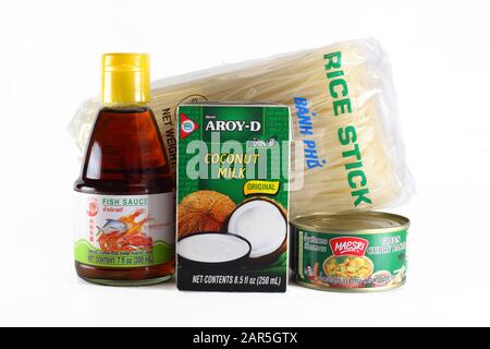 Thailändische Zutaten, grüne Currypaste, Reisnudeln, Kokosmilch, Fischsauce isoliert auf weißem Hintergrund. Ausschnitt für redaktionelle Verwendung Stockfoto