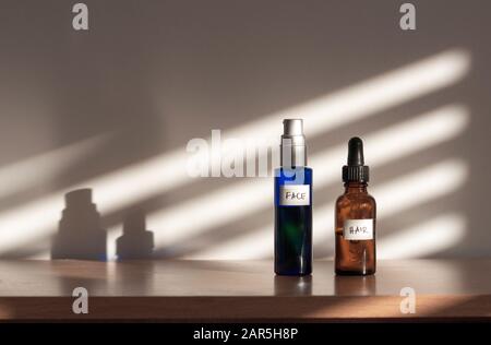 Hausgemachte Aromatherapie-Selbstversorgung: Gesichtsöl und Haarmassageöl in strahlenden und nachhaltigen Glastöpfen. Stockfoto