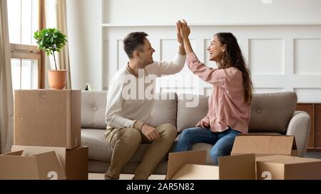 Glückliche junge Paare geben hohe fünf aufgeregt, zusammen zu bewegen Stockfoto