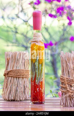 Gläser mit eingepickten peruanischen Chilipern auf Holztisch Stockfoto